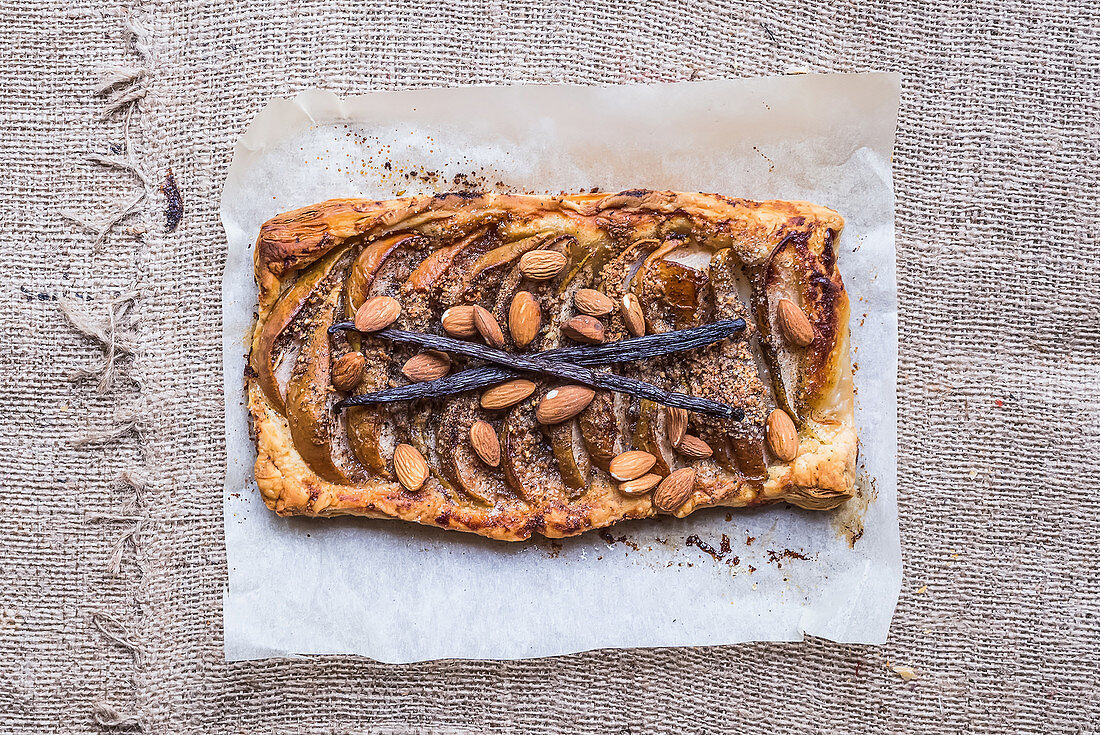 Rustic pear square galette with almond and vanilla over a sackcloth background