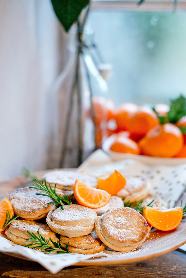 Mince Pies mit Puderzucker und Mandarinen zu Weihnachten