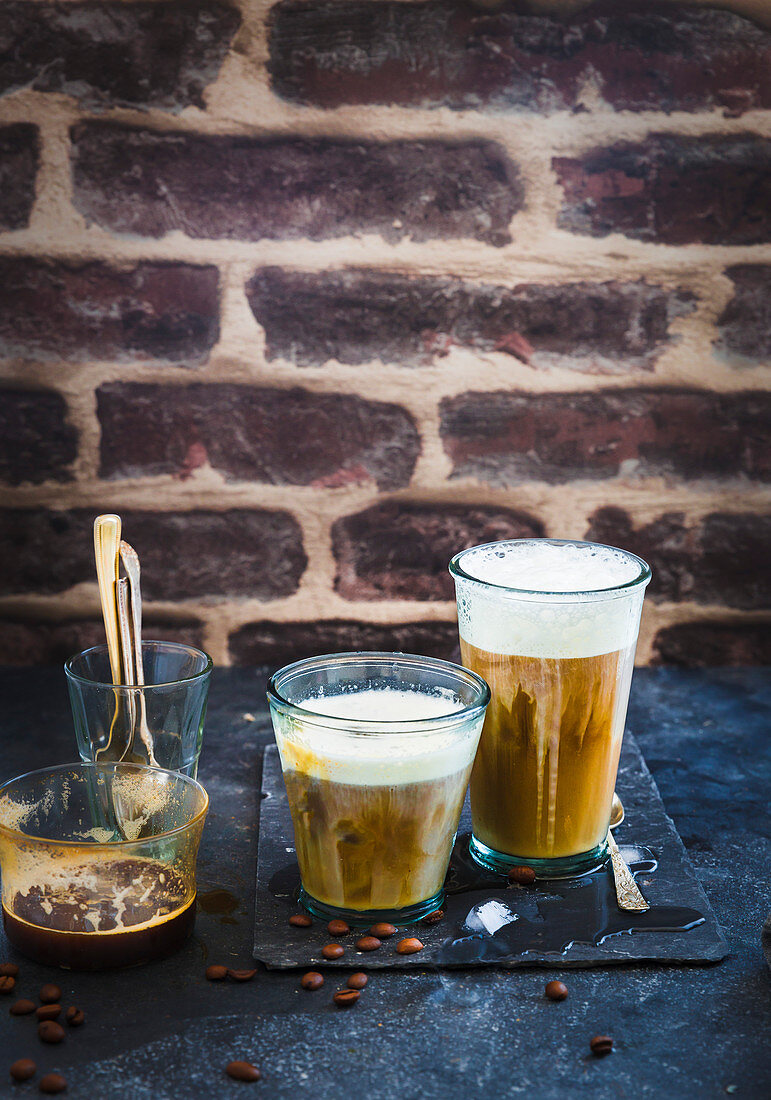 Iced Coffee Latte auf Schieferuntergrund vor gemauerter Wand