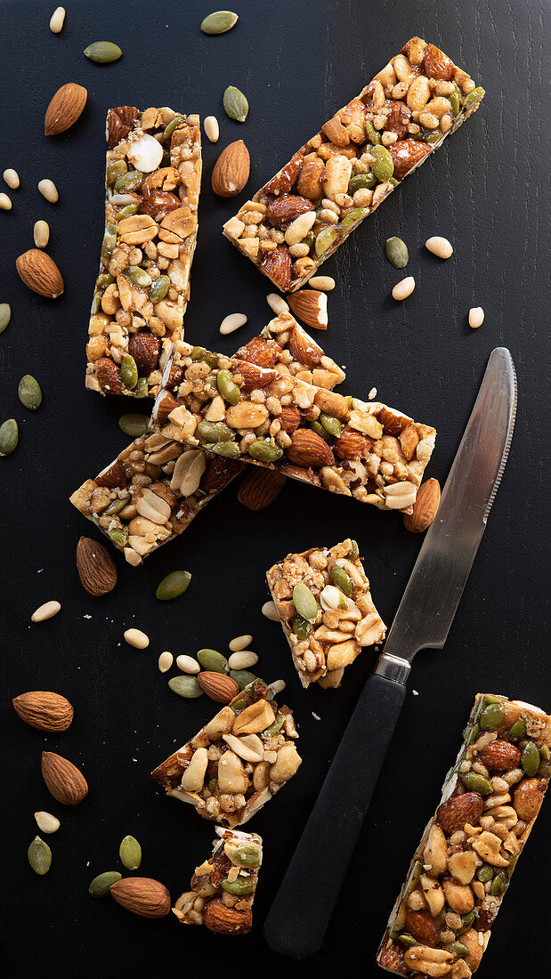 Nut and Seed Bars with a knife on a black blackground
