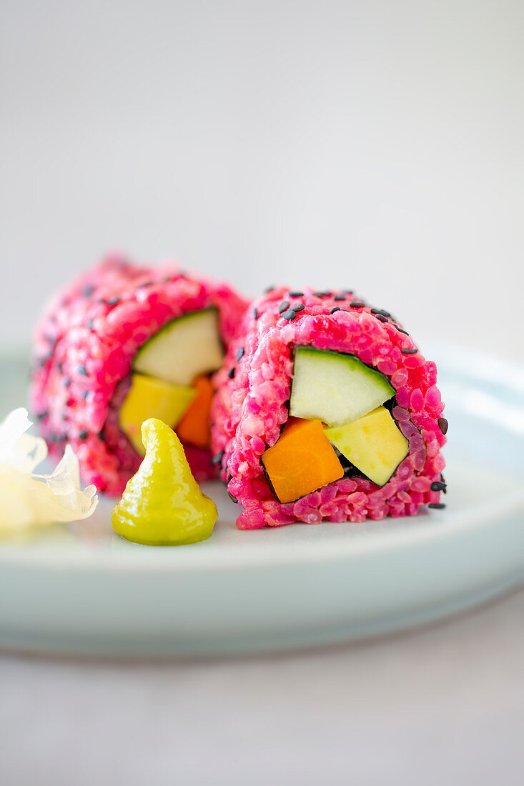 Vegan sushi with beetroot rice, avocado, carrots and cucumbers