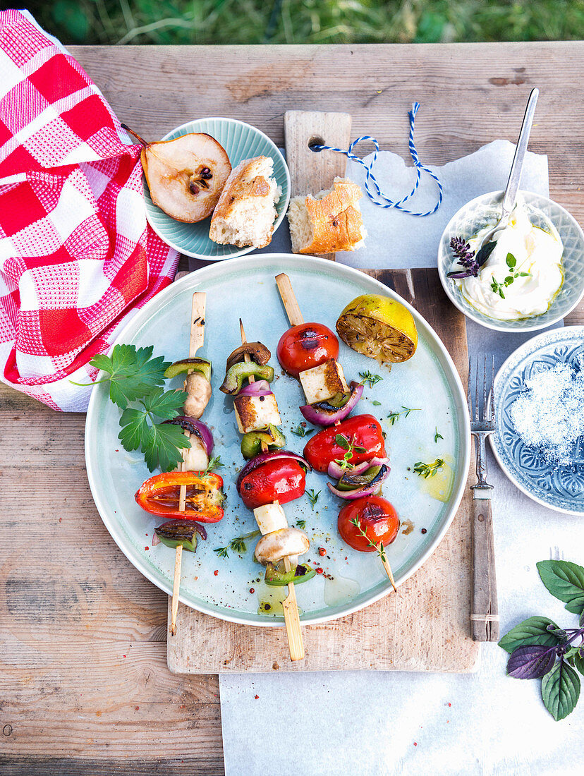 Grilled vegetable skewers with haloumi and baguette with crème fraîche and olive oil
