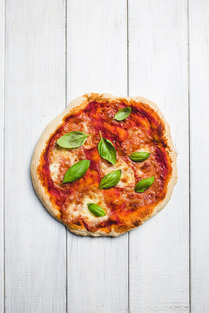 A pizza with mozzarella and basil (seen from above)