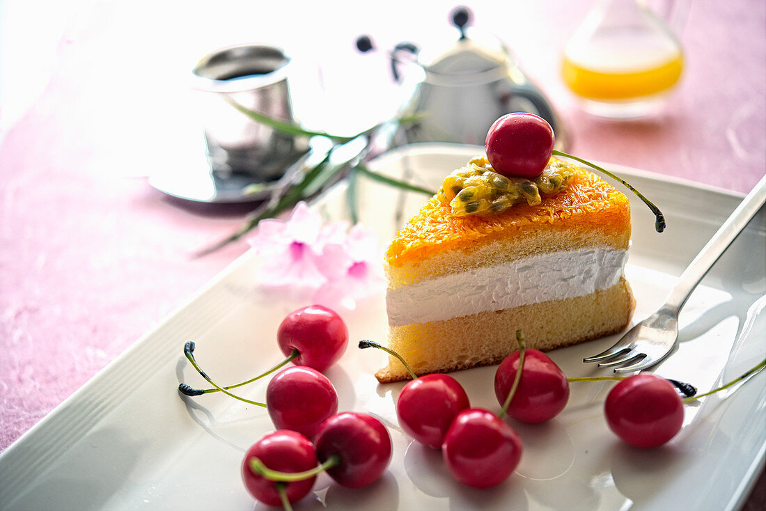 A slice of passion fruit cake with cherries