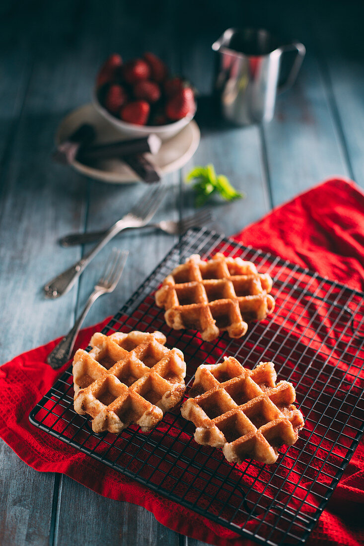 Waffles in a grid with icing sugar and strawberries