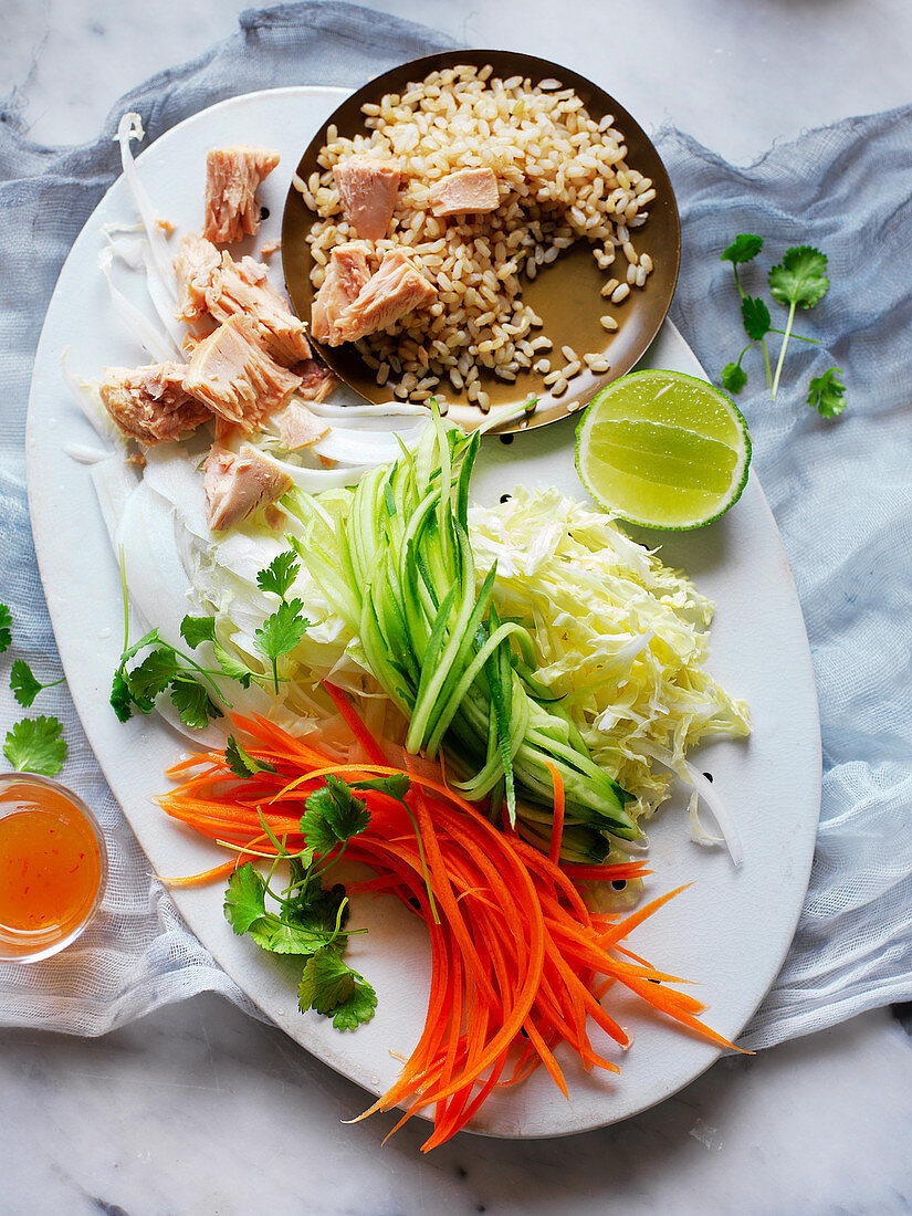 Salat mit braunem Reis, Thunfisch, Gemüse und Chilisauce