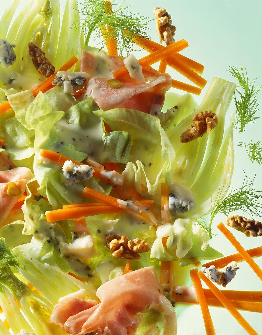 Lettuce with carrots, fennel, nuts, ham and cheese dressing