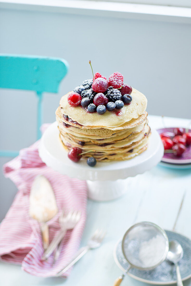 A pancake cake with fresh berries, raspberries, cherries and blueberries