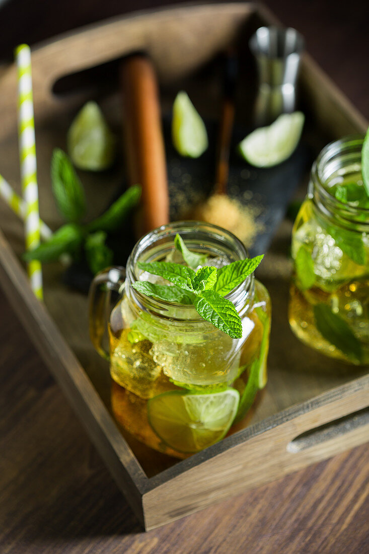 Mojito im Weckglas auf Holztisch mit Limetten und Minze