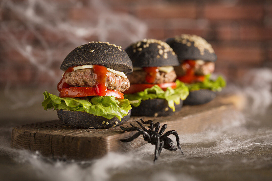 Schwarze Halloween-Burger mit Spinnweben