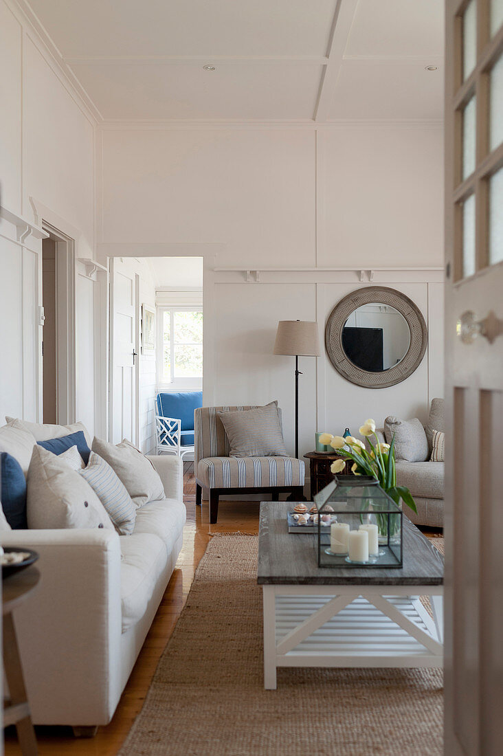 Sofa with linen cover, coffee table and armchairs in living room