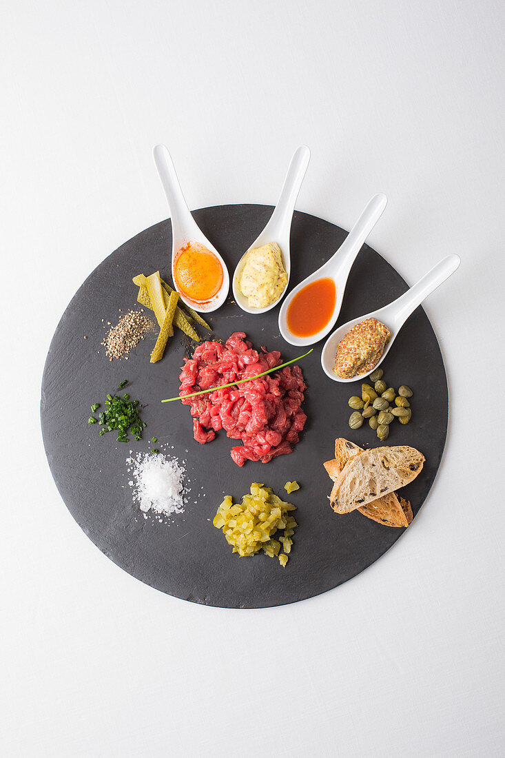 Beef tartare with egg, sauces, herbs and spices