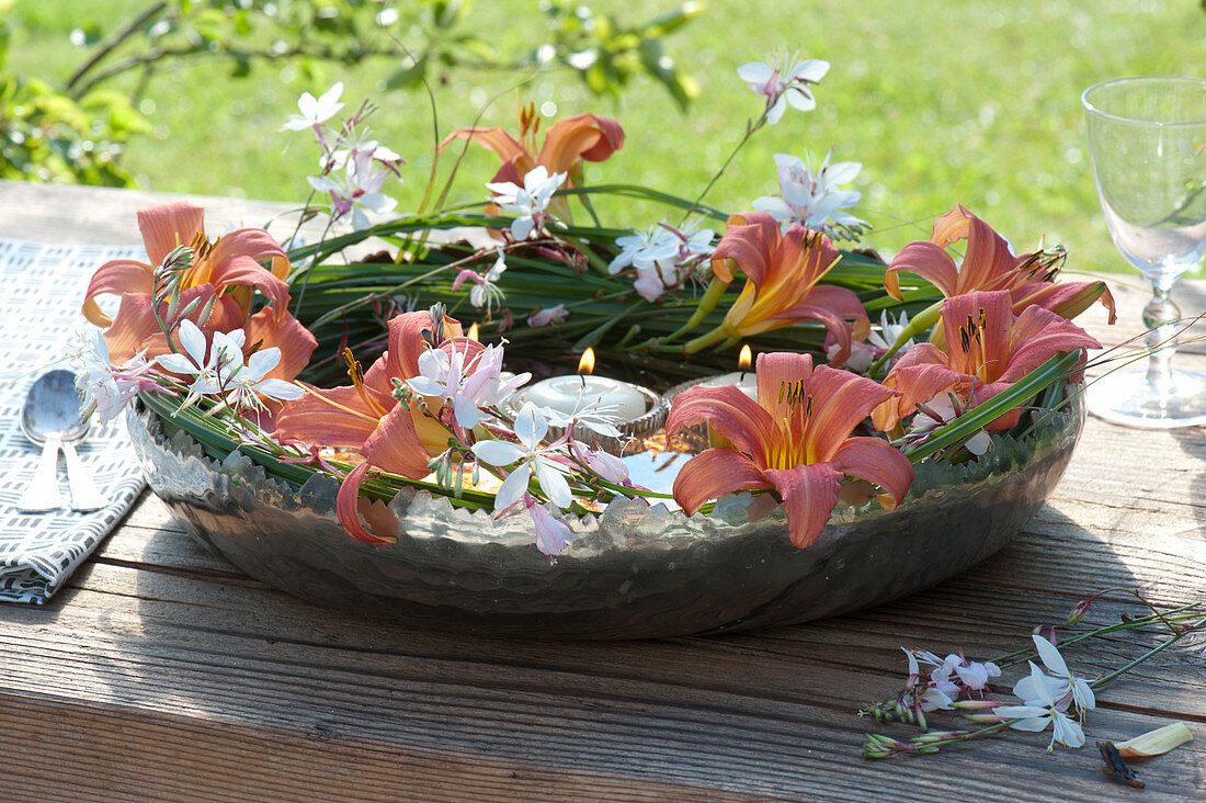 Wreath of daylilies and magnificent candles in a copper bowl