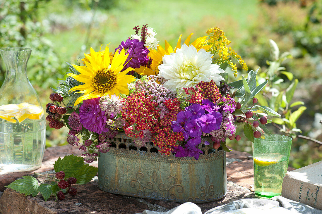 Gesteck aus Sonnenblumen, Dahlien und Schafgarbe in Jardiniere