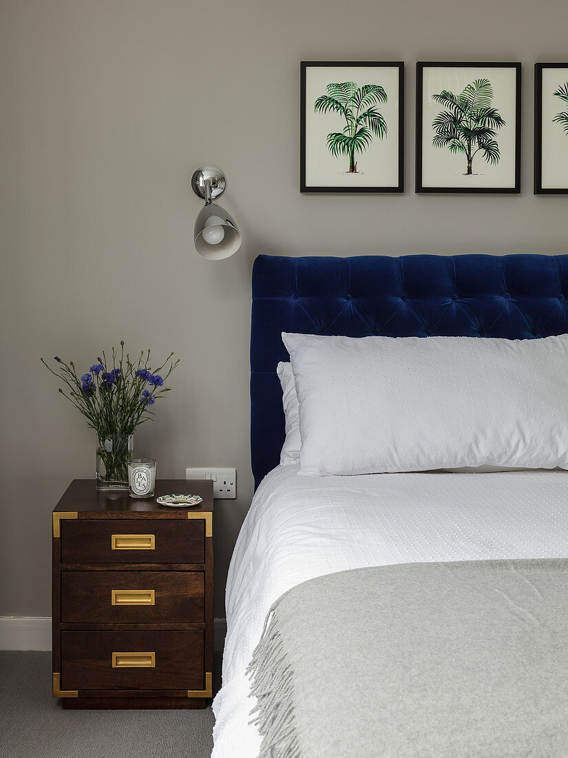 Doppelbett mit Bettkopfteil, Wandleuchte und Nachtkästchen im Schlafzimmer