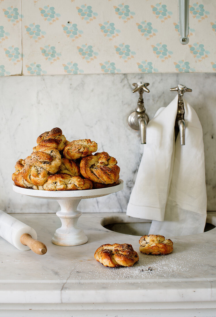 Swedish cinnamon buns on a cake stand and a marble work surface