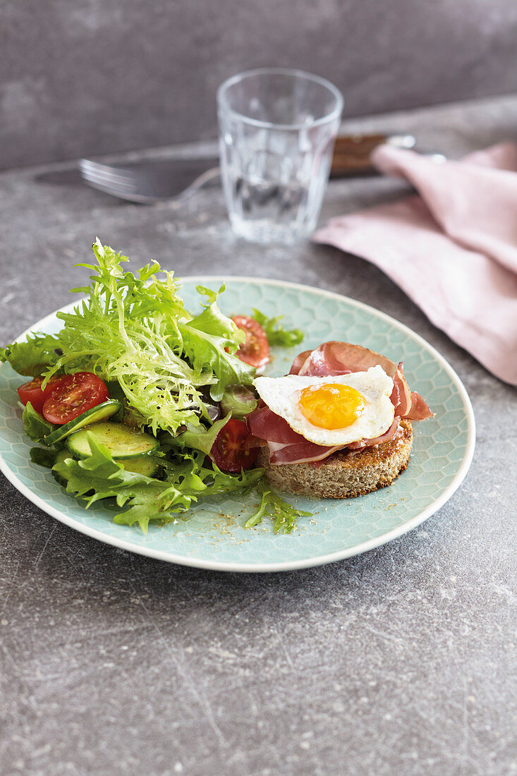 Ham and egg on toast with a colourful salad and truffle butter