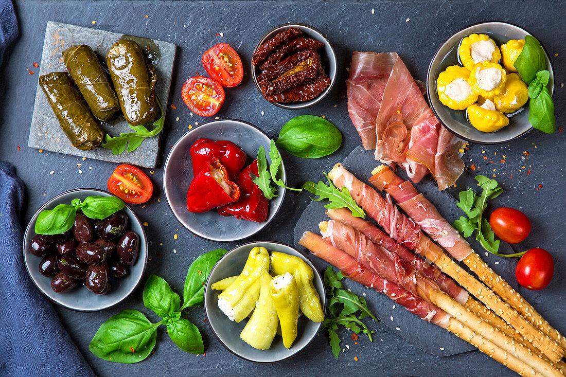 Verschiedene italienische Antipasti auf Schieferbrett