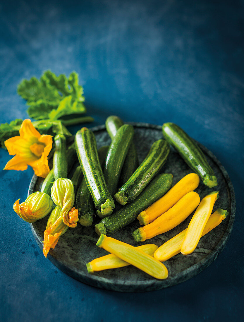 Zucchiniblüten und grüne und gelbe Zucchini