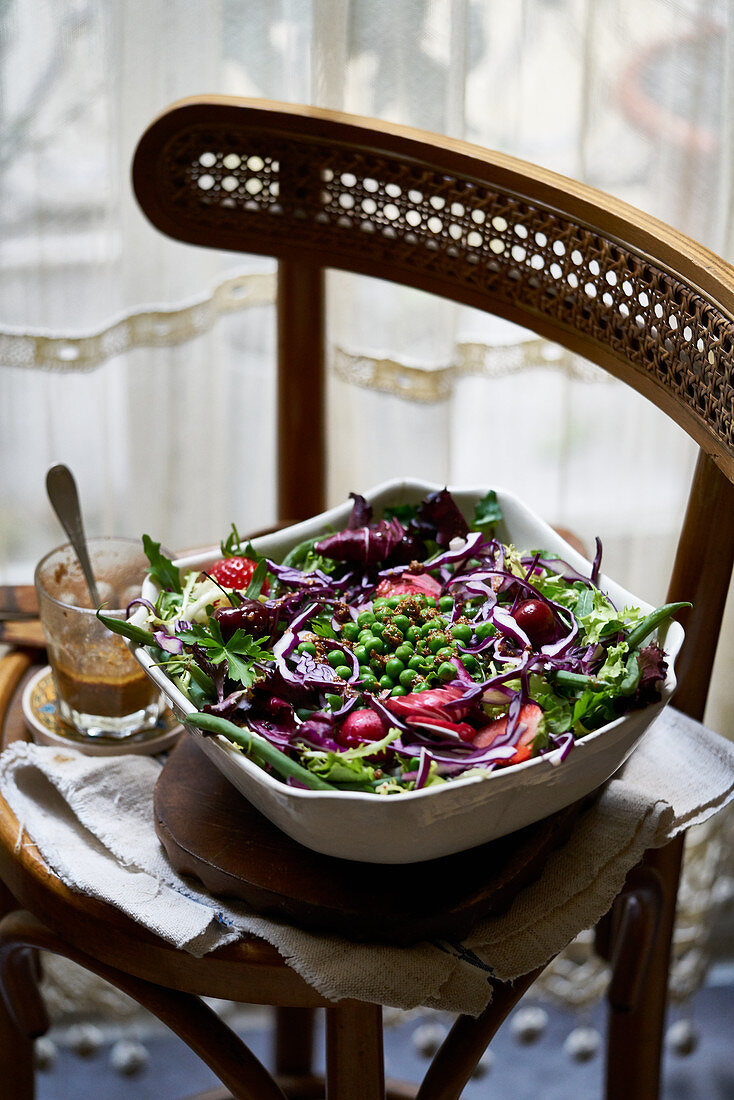Pea salad with red cabbage on a wooden chair