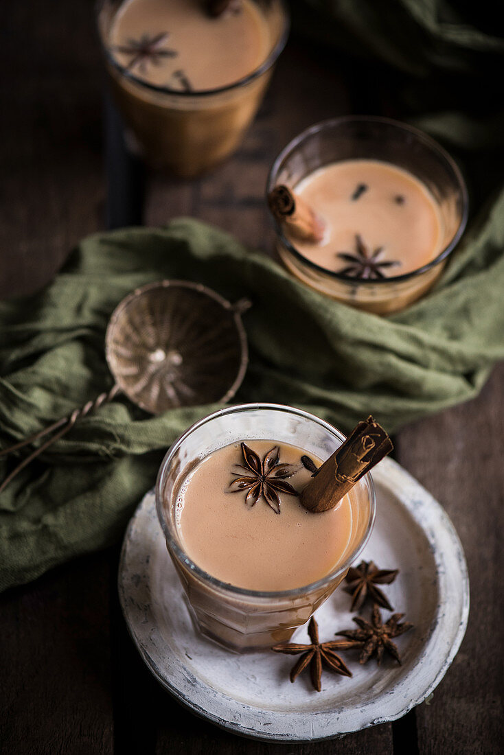 Mehrere Gläser Chai-Tee mit Sternanis und Zimtstangen