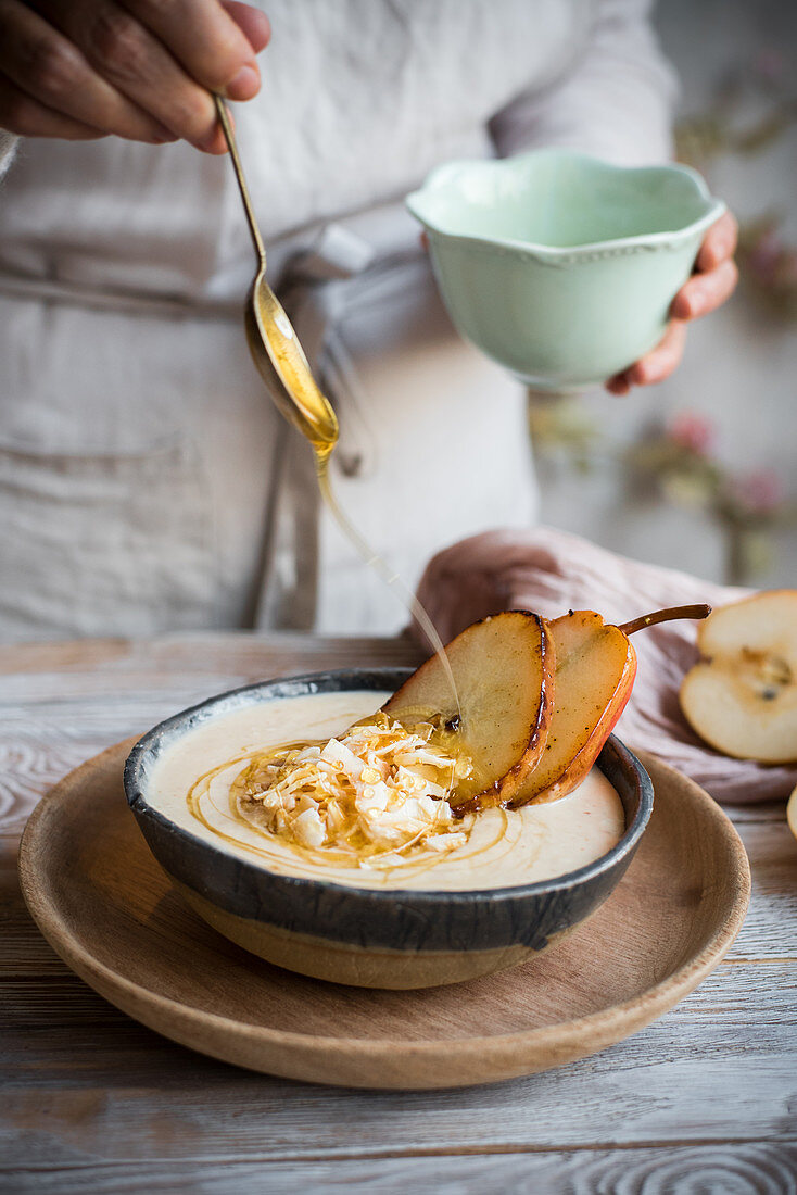 A bowl of porridge with caramelised pears and a drizzle of honey