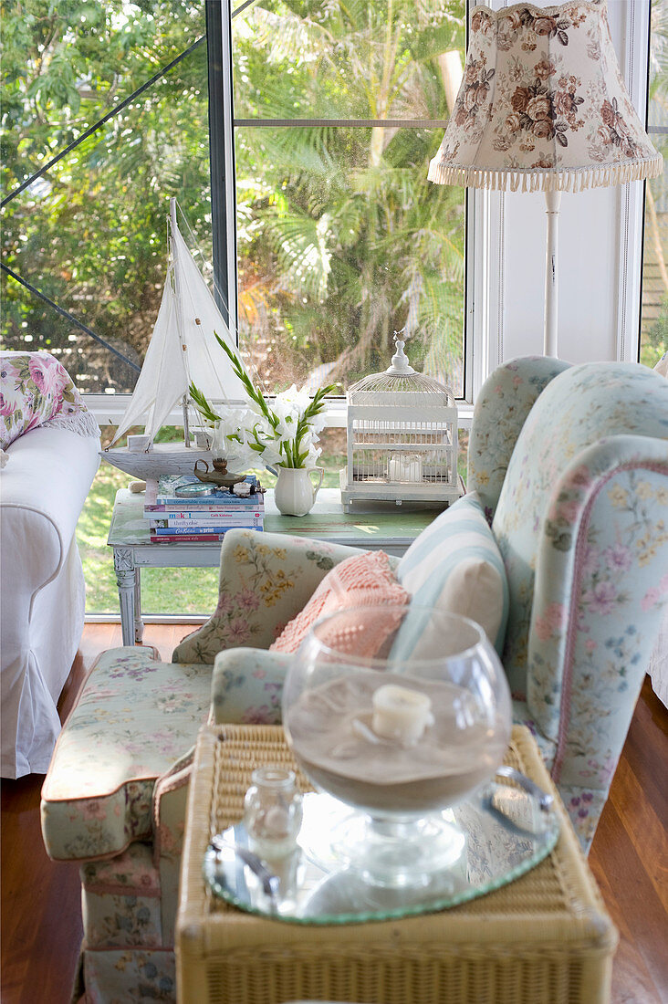 Floral textiles and glass wall in romantic living room