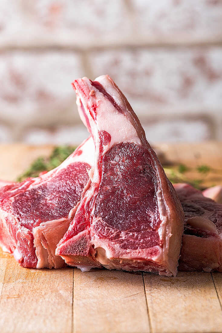 Raw beef chops on a wooden table