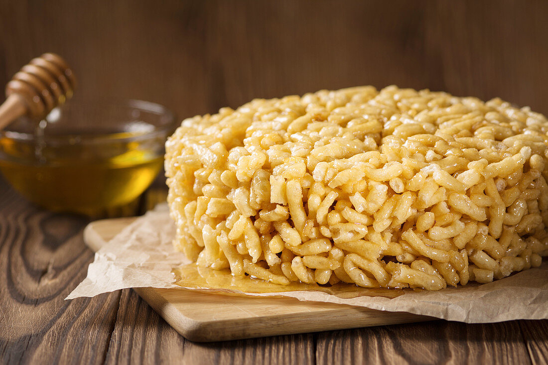 Chak chak with honey on a wooden background - Eastern sweetness Chak-chak, a national dish of Tatars and Bashkirs