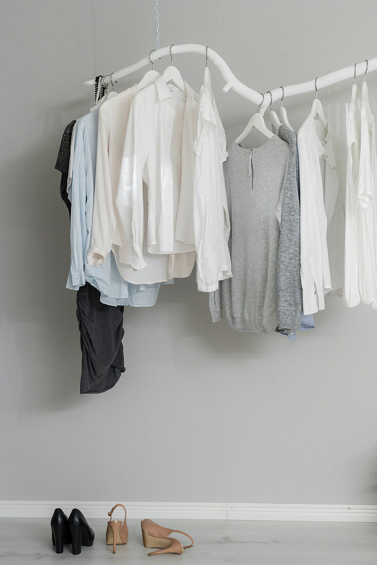 Clothing hung from DIY cloths rack made from white-painted branch