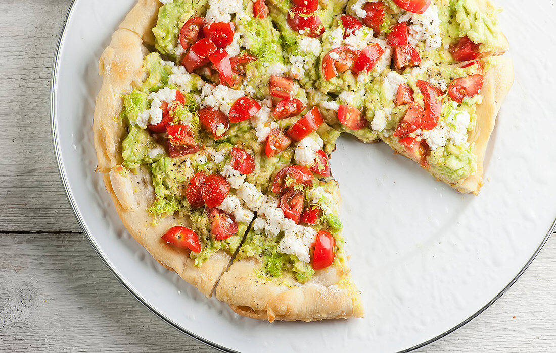 Pizza mit Avocado, Tomaten und Schafskäse