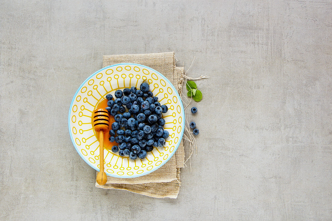 Fresh Wild blueberry in bowl with honey