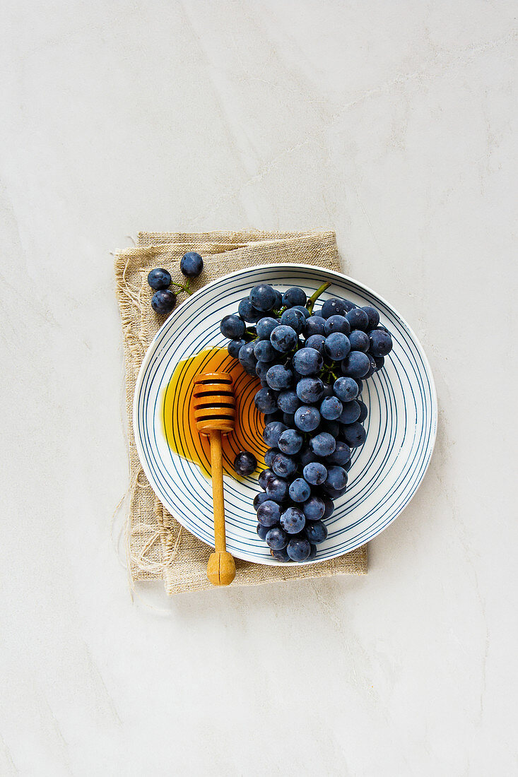 Fresh grape and honey on light background