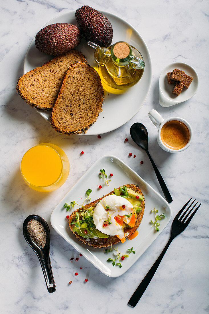 Brot mit Avocado und gekochtem Ei dazu Espresso und Orangensaft zum Brunch