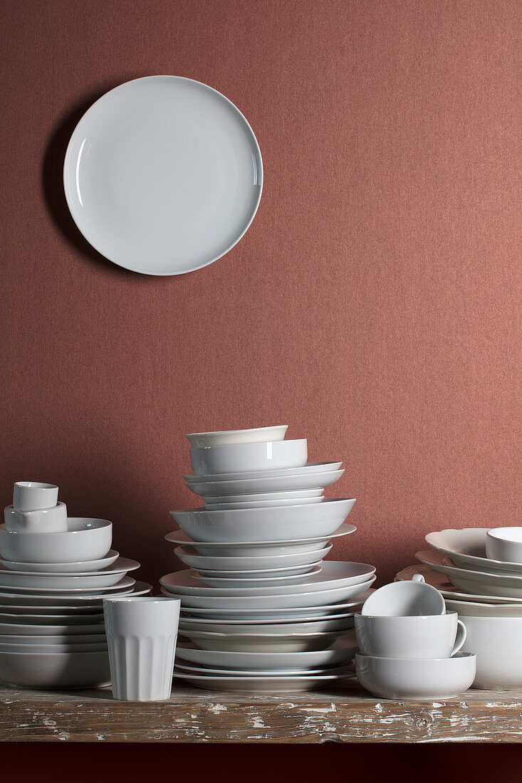 White crockery on table and white plate on wall