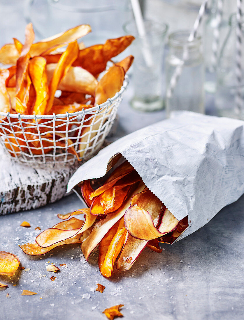 Süßkartoffelchips in Drahtkörbchen und Tüte