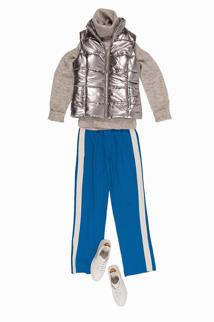 Grauer Rollkragenpullover, Steppweste in Silbermetallic, blaue, sportliche Hose und Sneaker