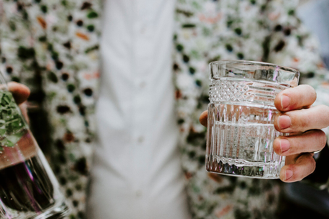 Hand hält Glas mit Gin