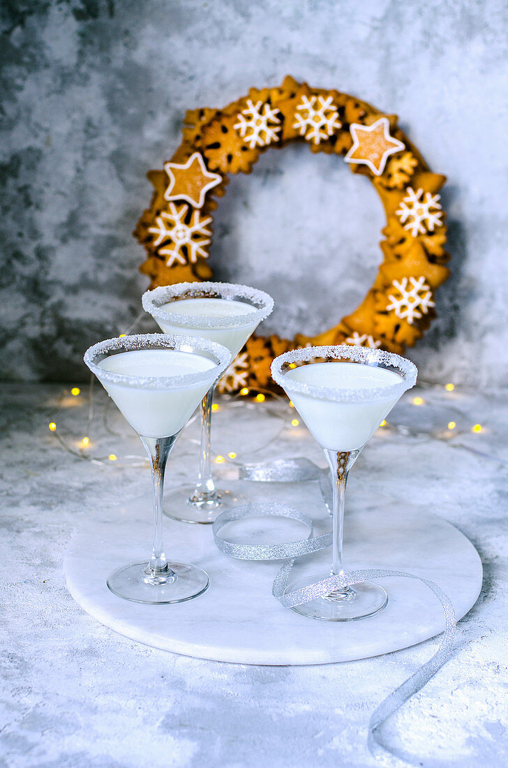 Drei Gläser Kokos-Martini und Plätzchenkranz zu Weihnachten