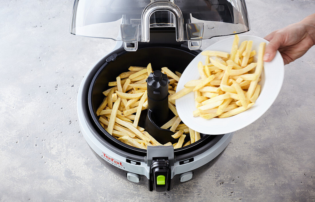 Chips being place in a hot-air fryer