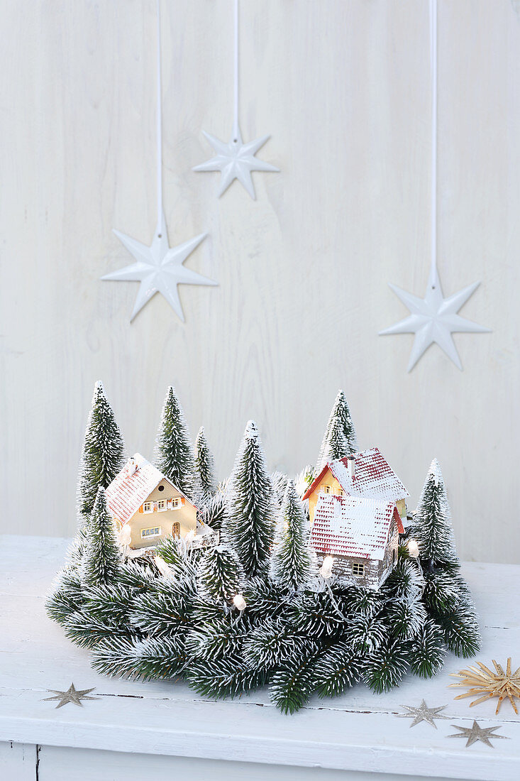 Tiny houses and model trees in miniature winter landscape
