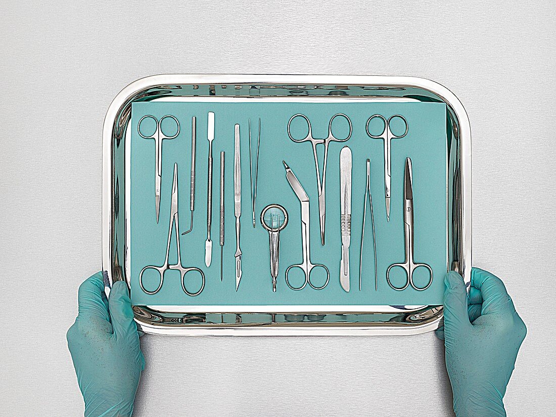 Person holding tray with surgical equipment