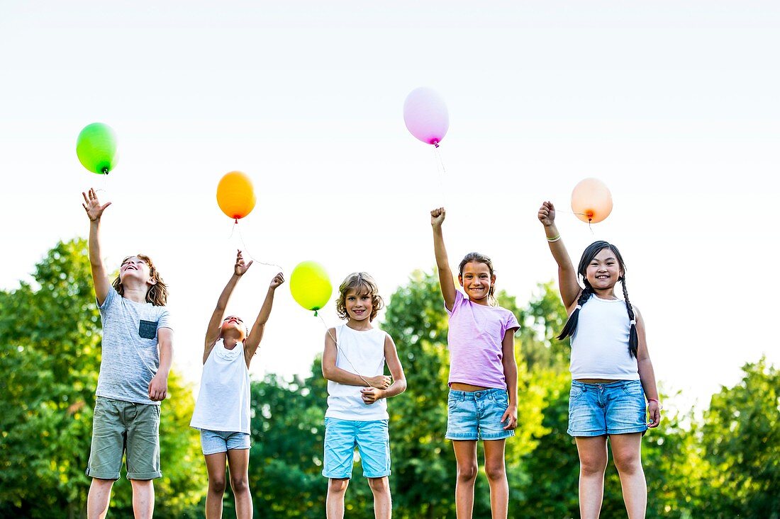 Children standing with balloons