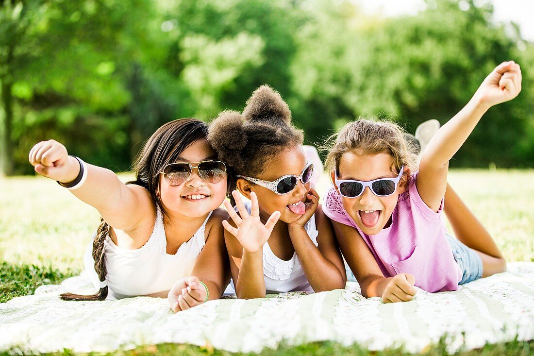 Girls lying on blanket in park