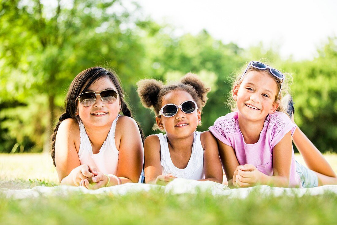 Girls lying on blanket in park