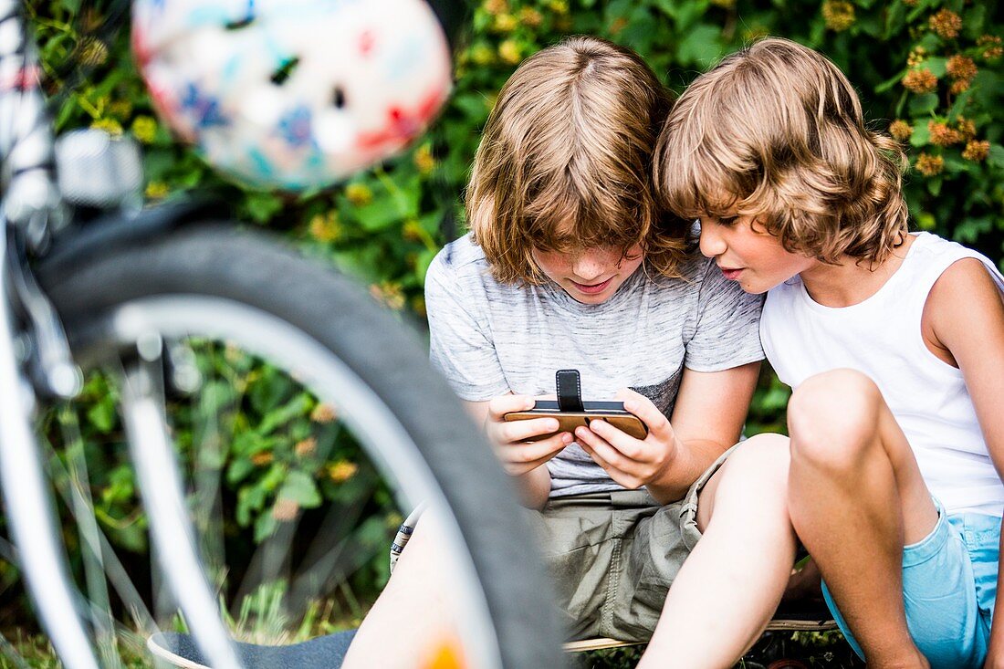 Boys playing games on mobile phone