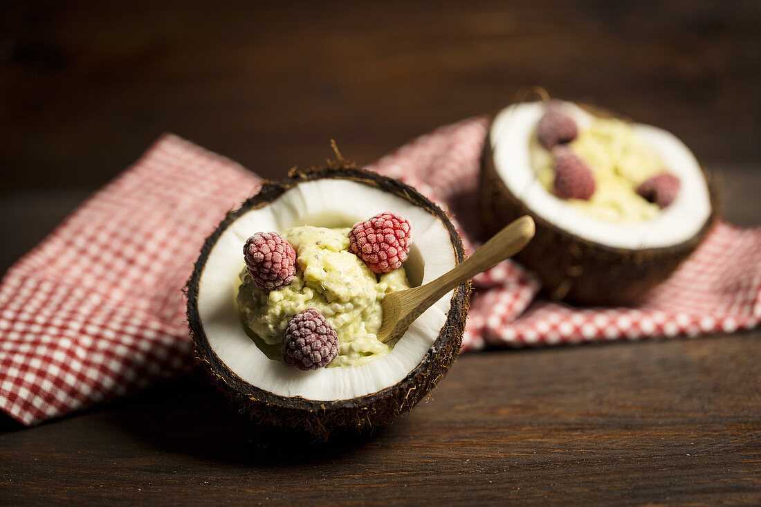 Chia and coconut ice cream with frozen raspberries in coconut bowls