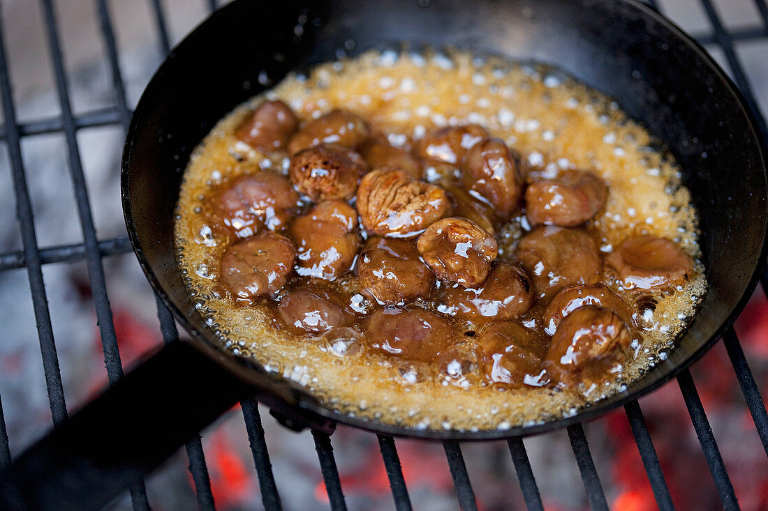 Roasting chestnuts in a pan on coals
