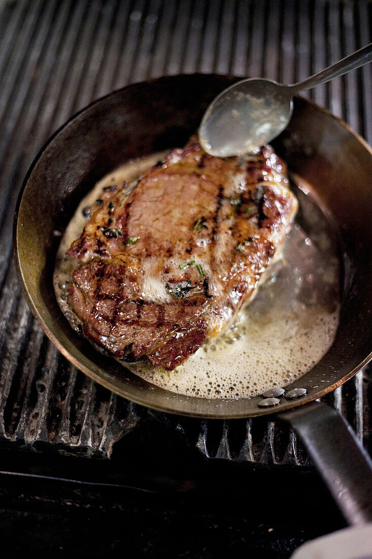 Steak mit Butter in Pfanne braten