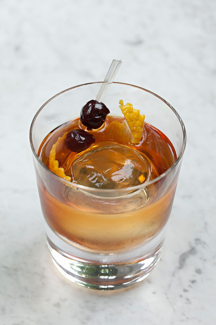 Whiskycocktail mit Eisball und Orangenschale